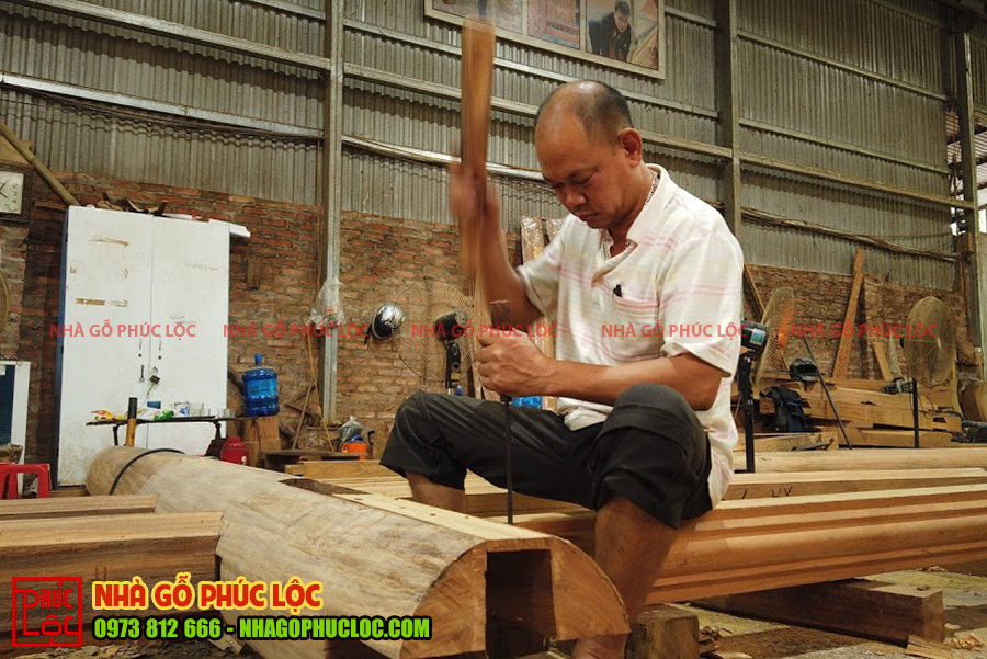 Hình ảnh người thợ đang gia công cột gỗ 